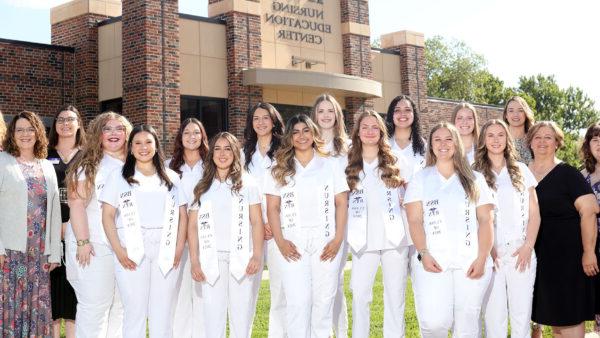 Individuals in nursing gear with faculty